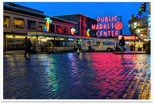 Seattle Public Market Center with colorful lights at sundown